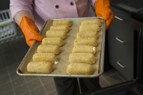 An associate holding a platter of deep fried twinkies